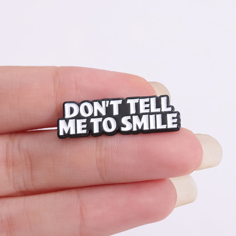 'Don't tell me to smile' enamel pin
