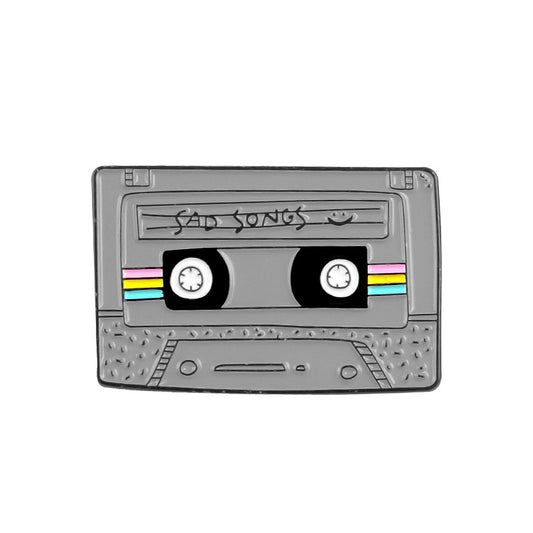 Cassette tape with 'sad songs' enamel pin